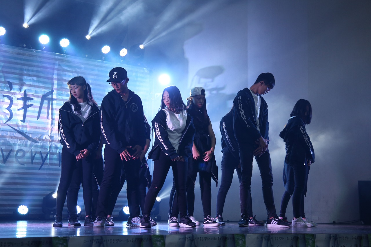 a photo of a group of individuals holding poses on a lit stage