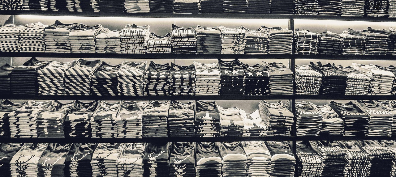 a display lined with a couple hundred black and white t shirts folded and organized neatly